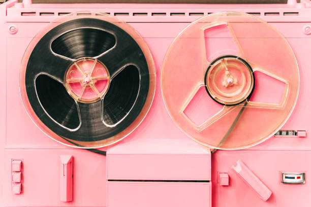 Pink retro tape-recorder device, tape deck or music player with reel tape discs. Old-fashioned radio machine with cassettes or cartridges used for radio data storing